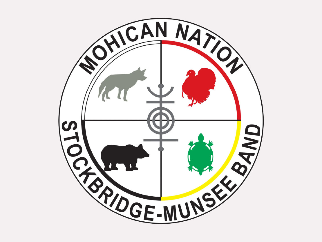 The tribal seal of the Stockbridge-Munsee Band of Mohicans. It is circular with icons of a wolf, turkey, bear, and turtle inside.