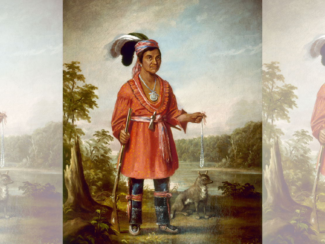 A painting of Austin E. Quinney. He is wearing a red long tunic and holding a rifle by his side in one hand. A dog is sitting behind him. They are in a wooded area by a river.